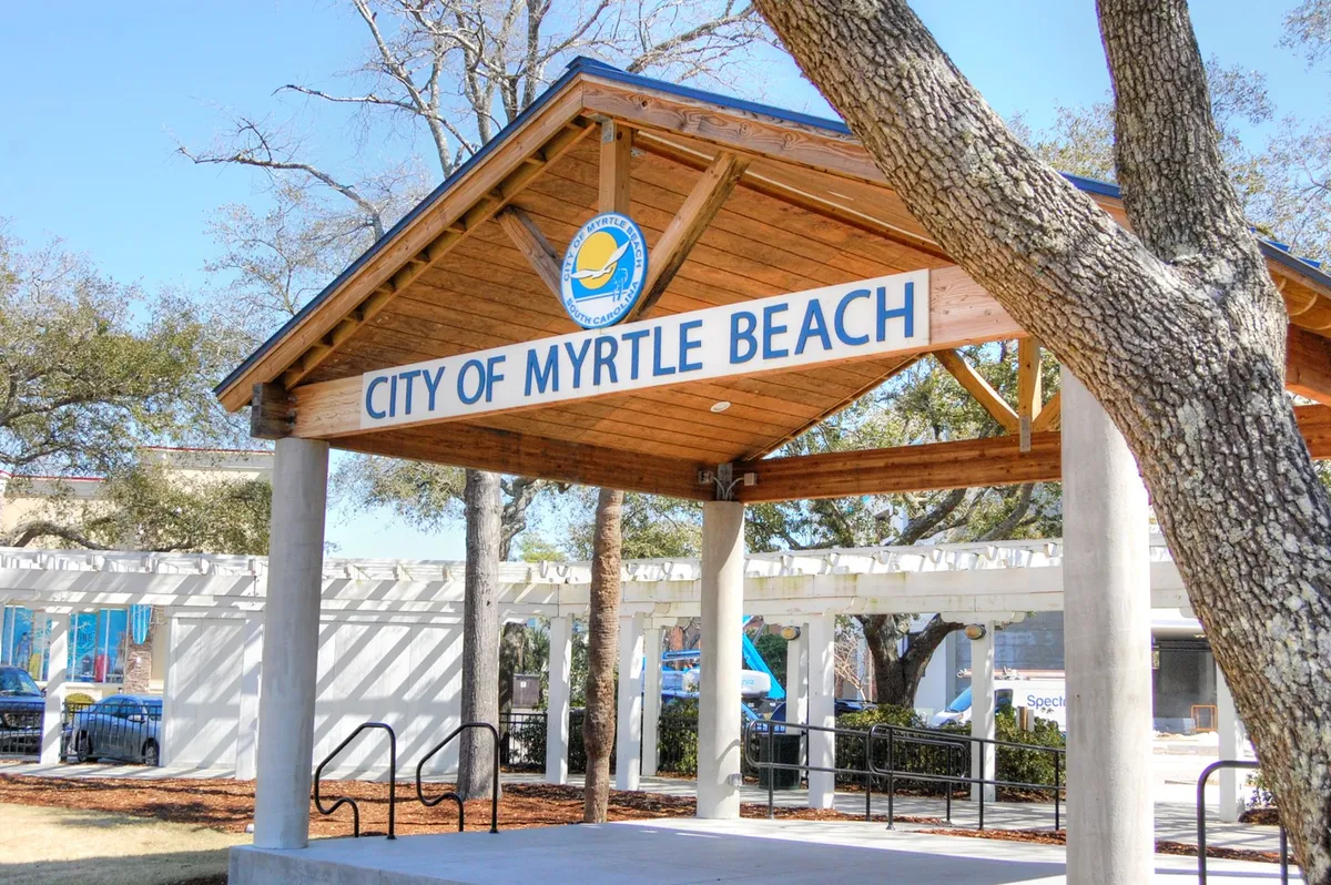 An inviting exterior view of a wooden structure with prominent signage set among lush greenery, signaling a hub for community events and gatherings. The scene reflects a welcoming neighborhood atmosphere and hints at the social opportunities available to long-term guests.